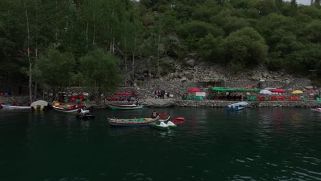 Un-Dron-Vuela-Hacia-Atrás-Sobre-Barcos-En-El-Lago-Kachura-Superior-En-Skardu