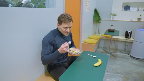 Glücklich-Lächelnder-Sportlicher-Mann,-Der-Nach-Dem-Training-Im-Fitnessstudio-Café-Vegetarischen-Salat-Isst---Blick-In-Die-Kamera