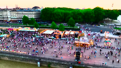 Multitudes-En-La-Place-Des-Quinconces-Que-Asisten-A-La-Feria-Del-Vino-Con-La-Noria-A-La-Derecha,-Toma-Aérea-Panorámica-A-La-Derecha