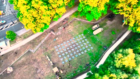 Drones-being-ready-for-nighttime-show-by-technicians-at-Wine-Fair,-Aerial-top-view-approach