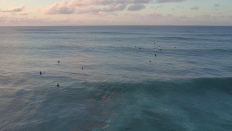 Surfers-Surfing-At-North-Shore-In-Hawaii-During-Sunset,-Aerial-Shot