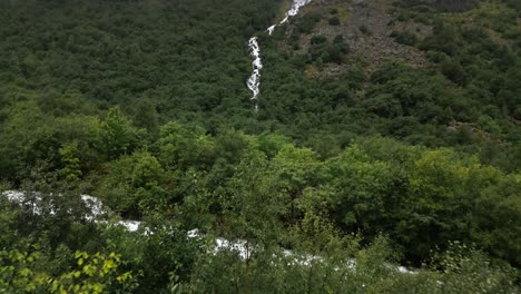 Wasserfall-In-Einem-Grünen-Wald-Mit-Vielen-Wolken,-Norwegen,-Natur,-Drohne