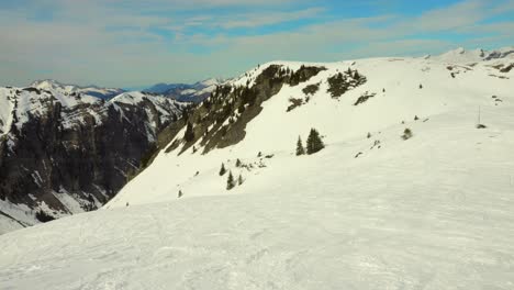 Snow-mountain-slope-in-french-Alps-leading-to-deep-valley-on-sunny-day