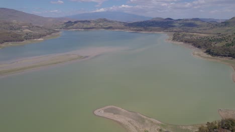 órbita-Aérea-Sobre-El-Lago-Seco-De-Pozzillo,-Sicilia,-Italia-Con-El-Monte-Etna-En-El-Horizonte-Mostrando-Los-Problemas-De-Sequía