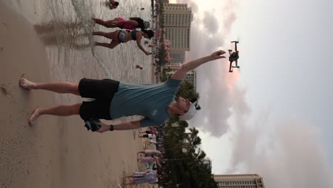 Mann,-Der-Inhalte-Erstellt-Hat,-Fliegt-Eine-Drohne-Am-Tropischen-Strand,-Vertikales-Video