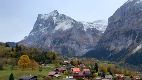 Grindelwald-gondola-ride-Switzerland-Swiss-Alps-valley-village-resort-ski-town-snowy-Jungfrau-Junfrangu-Lauterbrunnen-mountain-glacier-glacial-peaks-October-cloudy-autumn-evening-landscape-pan