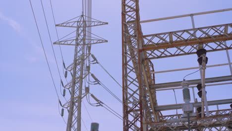 Low-angle-view-looking-up-at-power-lines-below-a-cloudy-sky