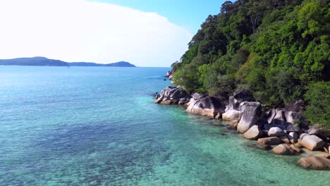 Tropical-paradise-secluded-serene,-sandy-beach-alongside-lush-forest-clear-blue-water