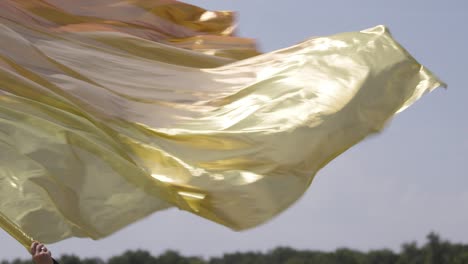 Goldene-Flagge-Wird-Im-Freien-Geschwenkt