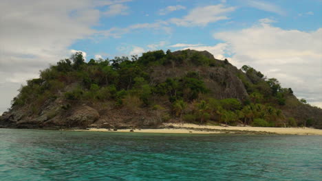 Castaway-Qalito-Malolo-Island-Tourism-Fiji-boat-ride-sailboat-Roro-Reef-coral-white-sandy-shores-rocky-boulder-hillside-tropical-palm-tree-paradise-Mamanuca-group-nature-landscape-to-the-right-slide