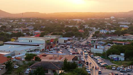 Golden-hour-sunset-glow-spreads-on-parked-cars-by-people-watching-Gran-Marcha-parade