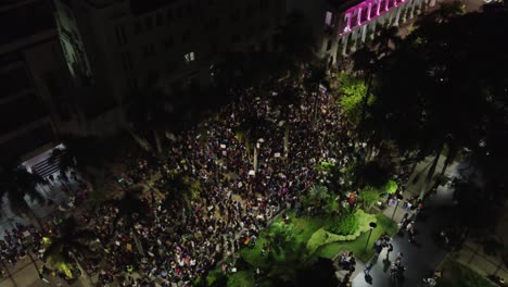 Vista-Aérea-Nocturna:-Manifestantes-Se-Reúnen-En-La-Plaza-De-La-Ciudad-Durante-La-Marcha-Del-Día-De-La-Mujer