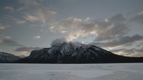 Captivating-timelapse-footage-of-the-early-morning-tranquility-on-Lake-Minnewanka,-Alberta,-with-Mount-Inglismaldie-silhouetted-against-the-dawn-sky