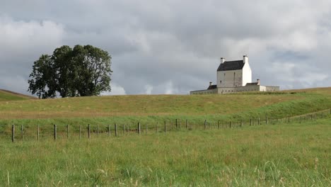 Landscape-with-white-Corgarff-Castle-and-tree-in-Scotland-at-nice-sunny-afternoon