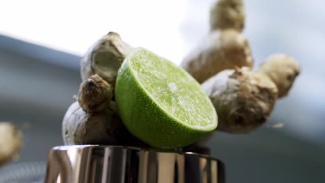 Beautiful-zoom-in-shot-to-lime-slice-and-ginger-cluster-inside-of-a-copper-cup-background-out-of-focus