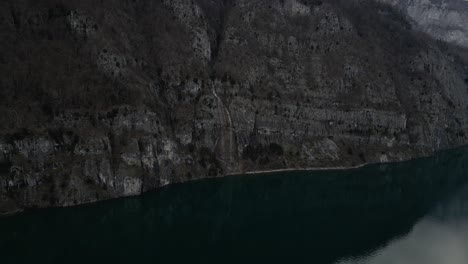 From-a-bird's-eye-perspective,-behold-the-rugged-beauty-of-mountain-landscapes-adorned-with-cascading-waterfalls,-framed-against-the-scenic-backdrop-of-Walensee-Unterterzen-in-Switzerland