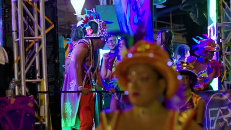 Frontal-view-of-Carnival-parader-performers-dancing-on-semi-truck-with-shining-lights-at-night