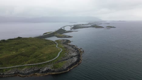 large-road-with-a-bridge-over-many-small-rocky-islands,-north-sea-and-mountains,-atlantikstreet,-archipelago-landscape,-norway,-nature,-drone