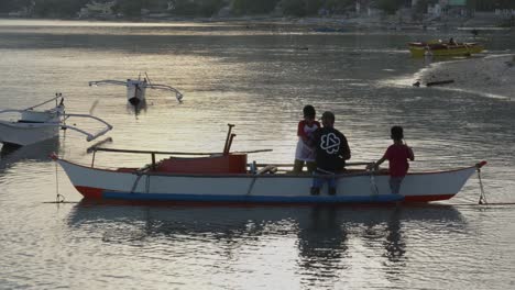 Fisherman-with-his-sons-getting-ready-to-go-fishing-on-a-canoe-in-the-Philippines