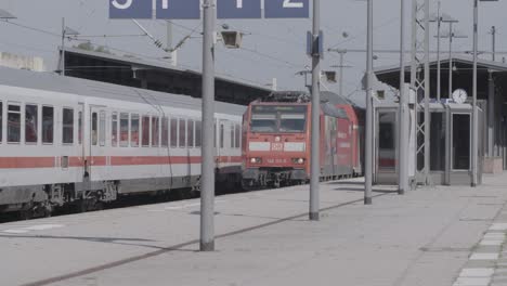 Tren-Rojo-Deutsche-Bahn-Llegando-A-Una-Estación-Durante-El-Día,-Tiempo-Despejado