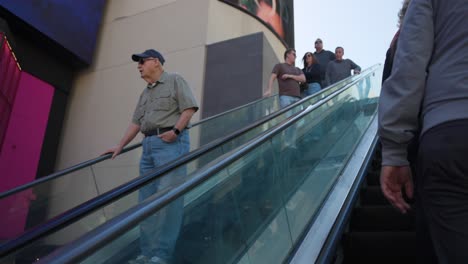 People-ride-an-escalator-down-outdoors-in-Las-Vegas,-Nevada