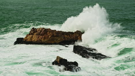 Kraft-Des-Ozeans,-Wenn-Die-Welle-In-Den-Felsen-Eindringt-Und-Schaumige-Gischt-Erzeugt