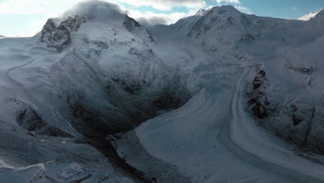 Incredible-world-famous-Gornergrat-Zermatt-Glacier-ice-crevasse-river-Swiss-Alps-top-The-Matterhorn-summit-ski-resort-landscape-scenery-aerial-drone-autumn-Railway-Switzerland-backward-reveal-motion