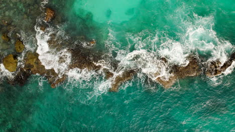 Idyllic-blue-exotic-waters-of-Blue-Lagoon-Nusa-Ceningan-around-rocks,-top-aerial