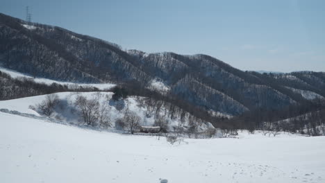 Tractor-Bring-Tourists-in-Trailer-Driving-Downhill-from-Snow-Capped-Mountians-at-Daegwallyeong-Sky-Ranch,-Gangwon-do,-Korea