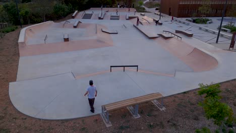 Skater-Zeigen-Faszinierende-Fähigkeiten-Und-Balance-Im-Abend-Skatepark,-Luftaufnahme