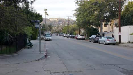 Eine-Nachbarschaftsstraße-Mit-Hollywood-Schild-Auf-Dem-Hügel-Im-Hintergrund-In-Los-Angeles,-Kalifornien