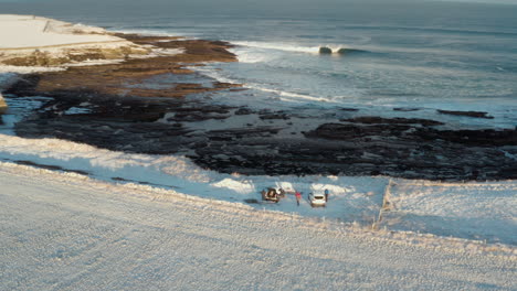 Explorers-set-up-camp-on-snow-covered-field-cliff-of-Wild-Atlantic-Way-Ireland