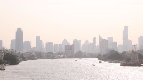 hazy-view-of-Bangkok-skyline-over-river-view-in-the-Rattanakosin-old-town-of-Bangkok,-Thailand