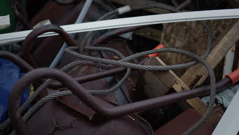 Iron-rope-and-rusty-wheelbarrow,-handheld