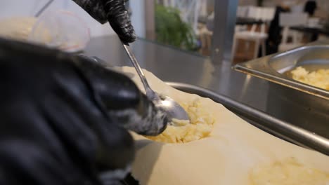 Der-Koch-Legt-Die-Füllung-Aus-Käse-Und-Kartoffeln-Auf-Den-Pierogi-Teig
