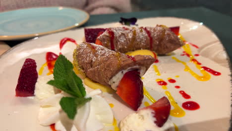 Traditional-Sicilian-Cannoli-filled-with-ricotta-cheese,-strawberries-and-cream,-tasty-sweet-Italian-dessert,-4K-shot