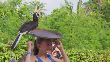 Turista-Y-Un-Cálao-En-Un-Espectáculo-De-Aves-En-El-Zoológico-De-Bali,-Indonesia---Plano-Medio