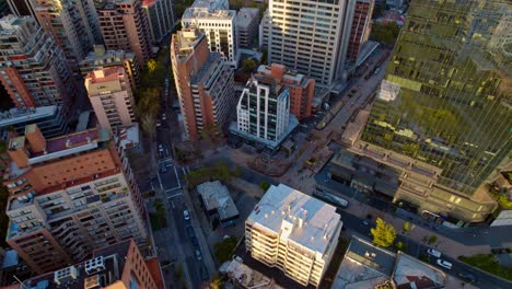 Aerial-panoramic-cityscape-at-santiago-de-Chile-El-Golf-neighborhood-streets-urban-buildings-at-daylight,-revealing-zoom-out-drone-South-american-downtown