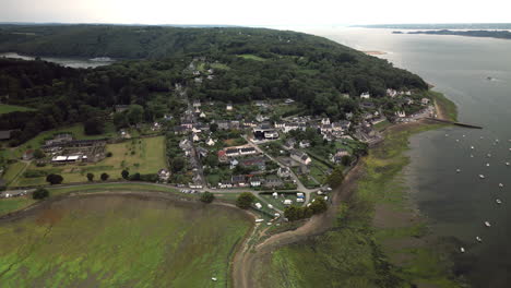 Backward-Tilt-Birds-Eye-View-of-a-Small-Town-by-the-Water-at-Low-Tide