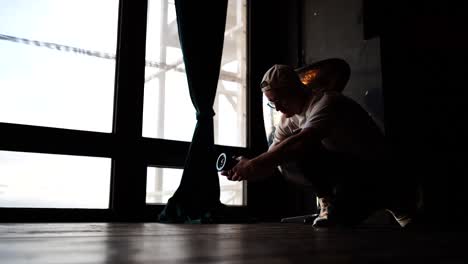 Cameraman-do-handheld-technique-during-filming,-indoor-studio-with-large-windows