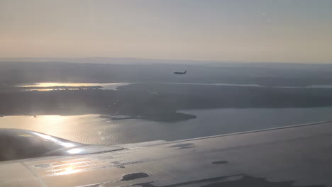 Sunlit-lake-view-from-an-airplane-with-another-aircraft-in-the-distance