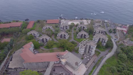 Aerial-orbit-over-the-abandoned-unfinished-luxury-hotel-resort-near-Catania,-Sicily,-Italy