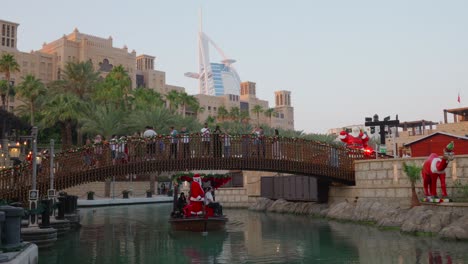 Souk-Madinat-Jumeirah,-Abra-boat-trip-on-the-water-canal,-in-the-sunlight,-within-the-Madinat-Jumeirah-resort-complex