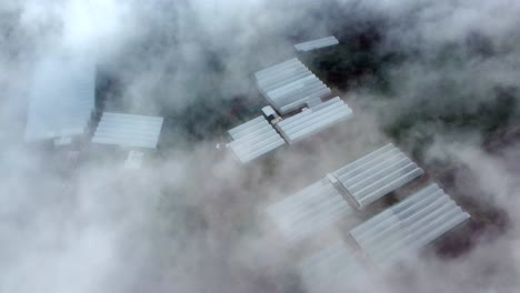 Aerial-top-down-of-dense-clouds-and-greenhouses-on-farm-field-in-Mexico