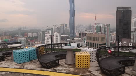 vibrant-colorful-sunset-into-dusk-shot-of-Merdeka-118-Tower,-the-second-tallest-building-in-the-world-from-a-rooftop-bar-in-Kuala-Lumpur,-Malaysia