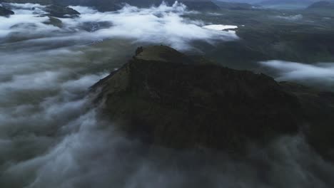 Mysterious-cinematic-view-on-mountain-above-clouds-in-Iceland,-aerial