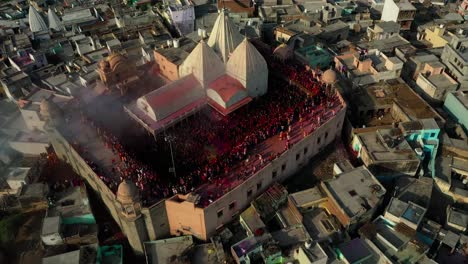 many-people-are-going-outside-through-the-temple-playing-dhuletti-and-coloring-on-others-and-doing-darshan-and-many-jatras-going-to-the-roof-of-the-temple-and-coloring