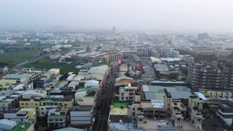 A-dense,-urban-landscape-at-dusk,-hinting-at-the-bustling-life-in-the-city,-with-a-hazy-sky,-aerial-view