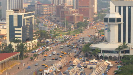 Cars-Driving-Through-The-Highway-Along-The-City-Buildings-In-Yaounde,-Cameroon,-Africa