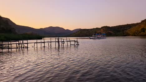 Amanecer-Dorado-En-El-Mar-Y-Las-Montañas-Con-Un-Pequeño-Pontón-De-Madera-En-Filipinas